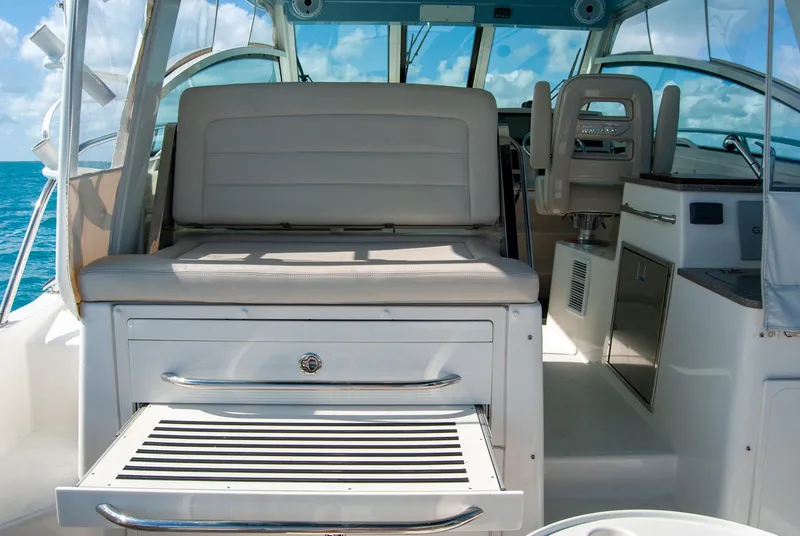 Slide: The Image of 2021 Boston Whaler 345 Conquest interior with seating and storage, ocean view in background. - 48