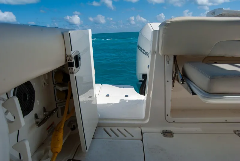 Slide: The Image of Boston Whaler 345 Conquest 2021 boat interior with open hatch, ocean view, and seating. - 17