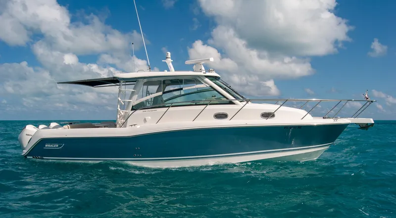 Slide: The Image of 2021 Boston Whaler 345 Conquest boat on clear blue ocean under a partly cloudy sky. - 1