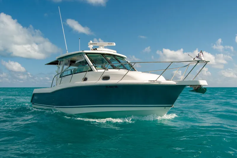 Slide: The Image of 2021 Boston Whaler 345 Conquest cruising on clear blue ocean under a sunny sky. - 6
