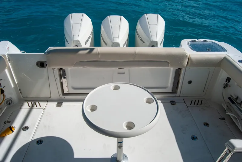 Slide: The Image of Boston Whaler 345 Conquest 2021 boat deck with table and four outboard engines. - 16
