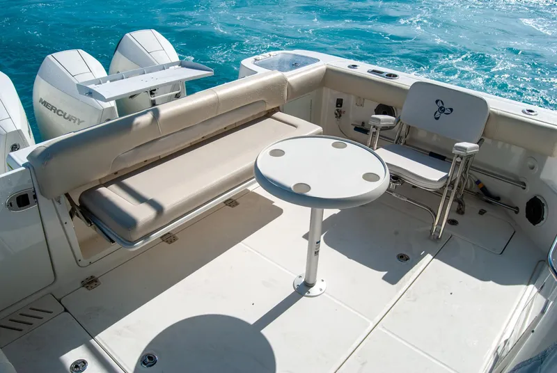 Slide: The Image of Boston Whaler 345 Conquest 2021 boat deck with seating and table, ocean backdrop. - 14