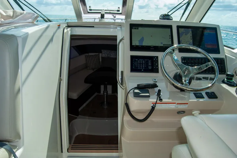 Slide: The Image of 2021 Boston Whaler 345 Conquest helm with navigation screens and cabin entrance. - 22