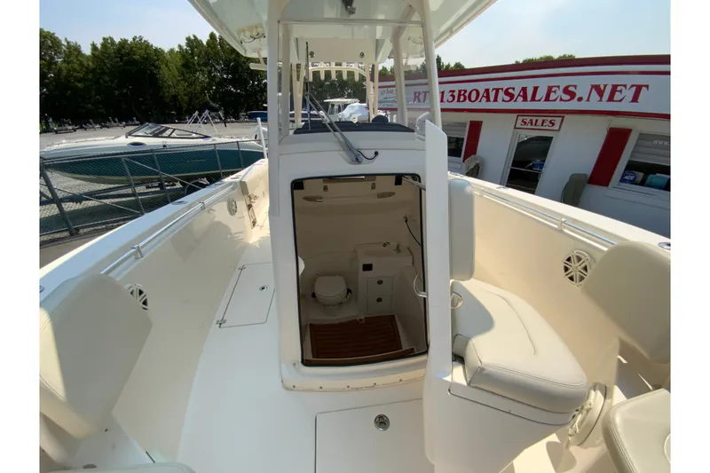 Slide: The Image of 2018 Cobia 301 Center Console boat interior with open cabin door at marina. - 27