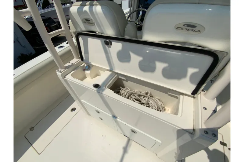 Slide: The Image of 2018 Cobia 301 Center Console boat storage compartment with rope inside. - 18
