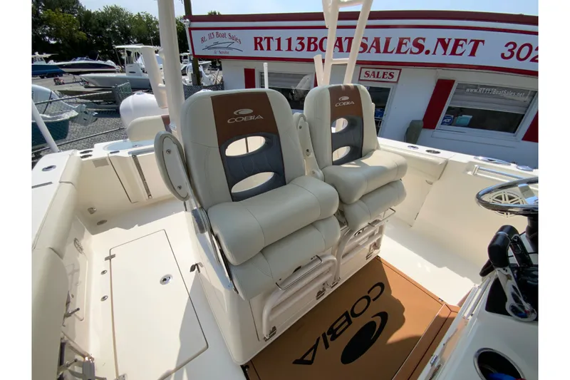 Slide: The Image of 2018 Cobia 301 Center Console boat interior with dual cushioned seats at a boat sales location. - 29