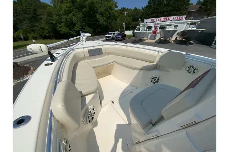 Slide: The Image of 2018 Cobia 301 Center Console boat interior at dealership, showcasing seating and speakers. - 25