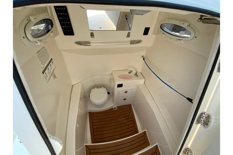 Slide: The Image of 2018 Cobia 301 Center Console boat interior with toilet and sink. - 28