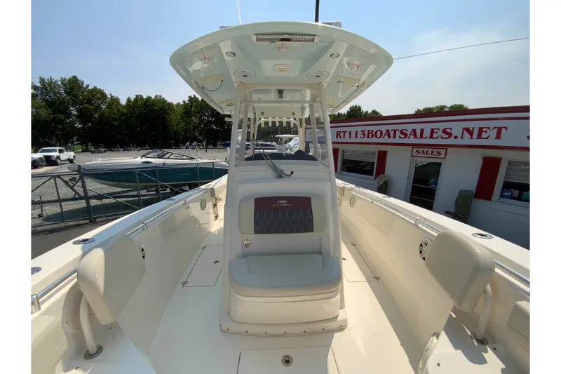 Slide: The Image of 2018 Cobia 301 Center Console boat at dealership, showcasing spacious deck and seating. - 23