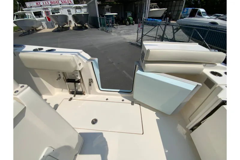 Slide: The Image of 2018 Cobia 301 Center Console boat interior at dealership, showcasing seating and storage. - 31