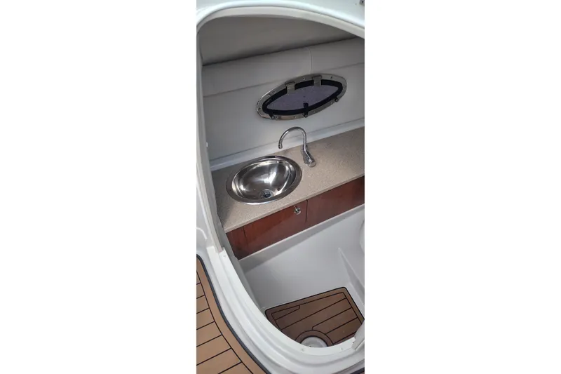 Slide: The Image of Interior of 2013 Crownline Eclipse E4 boat featuring a compact sink and porthole window. - 21