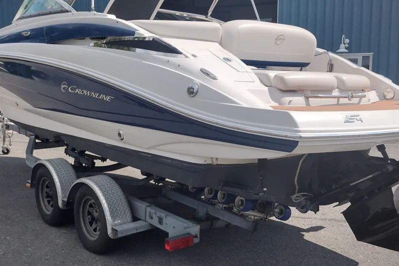 Slide: The Image of 2013 Crownline Eclipse E4 boat on trailer, blue and white exterior, parked outdoors. - 7
