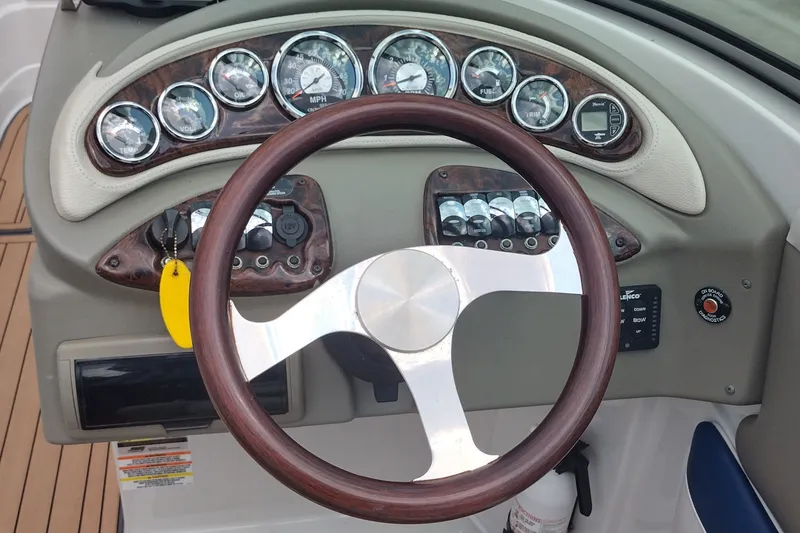Slide: The Image of Dashboard of a 2013 Crownline Eclipse E4 boat with wooden steering wheel. - 16