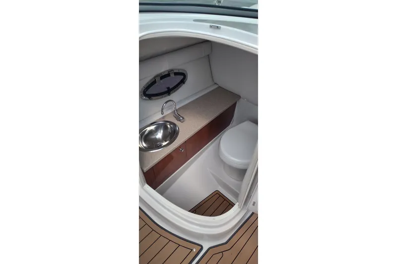 Slide: The Image of Interior of 2013 Crownline Eclipse E4 boat featuring a compact bathroom with sink and toilet. - 20