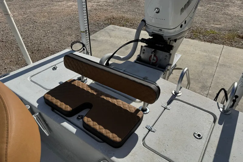 Slide: The Image of 2021 Haynie 25 Magnum boat interior with cushioned seating and motor detail. - 14