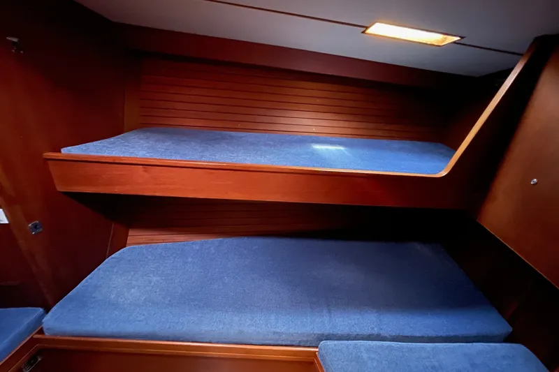 Slide: The Image of Interior of 1986 Baltic 48 DP yacht with wooden bunk beds and blue cushions. - 25