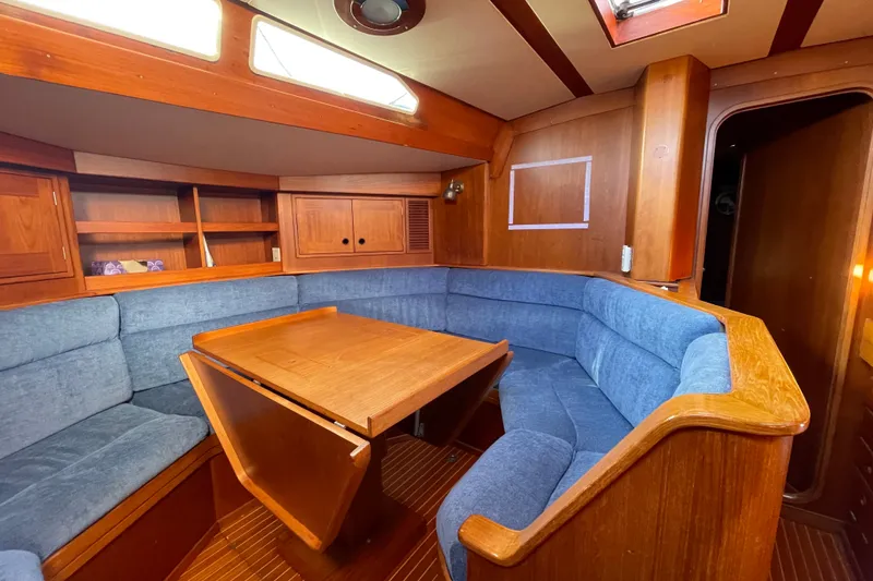 Slide: The Image of Cozy interior of 1986 Baltic 48 DP yacht with wooden furnishings and blue seating. - 17