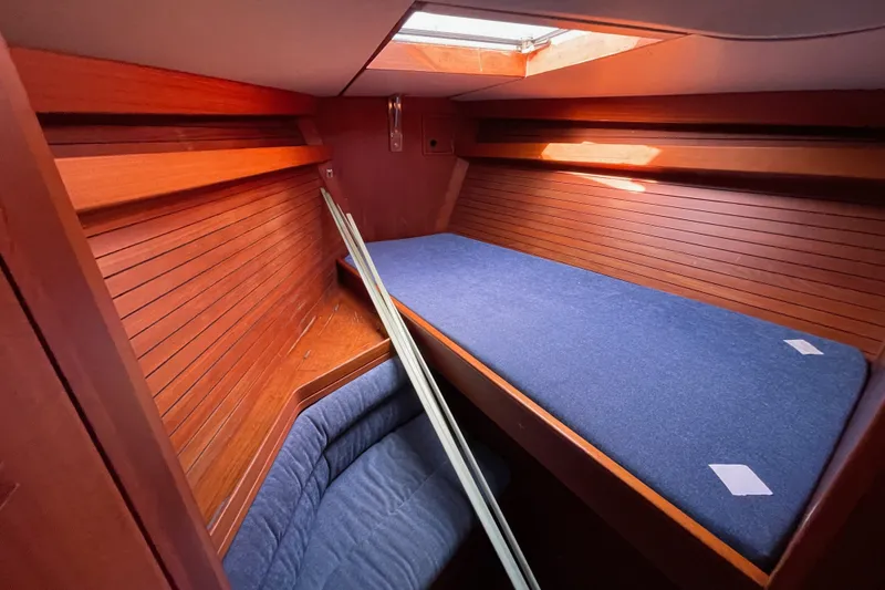 Slide: The Image of Interior cabin of 1986 Baltic 48 DP yacht with wooden paneling and blue cushions. - 26