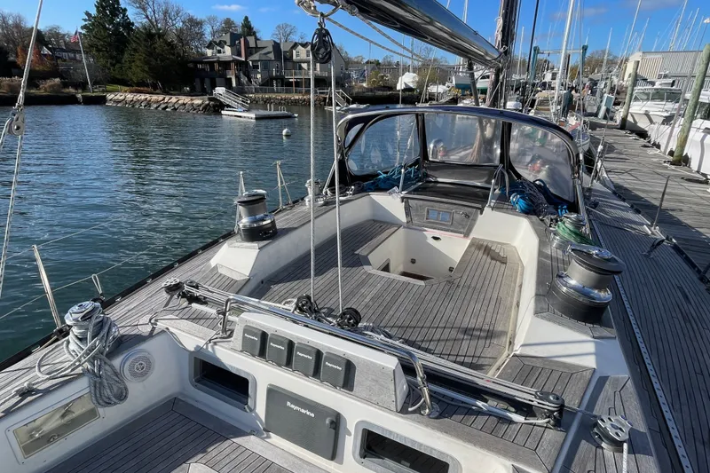Slide: The Image of 1986 Baltic 48 DP sailboat docked, showcasing deck and cockpit area with clear skies. - 10