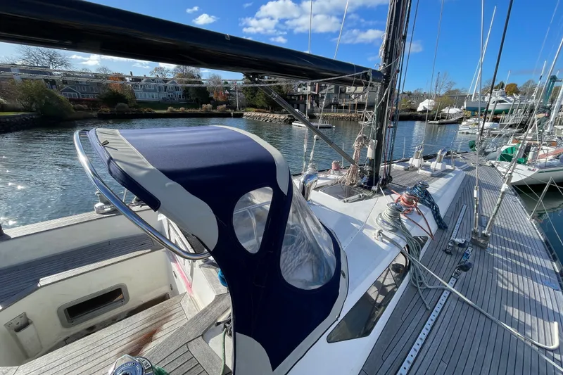 Slide: The Image of 1986 Baltic 48 DP sailboat docked, featuring sleek design and blue canopy. - 11