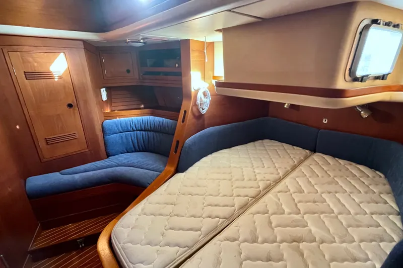 Slide: The Image of Cozy cabin interior of a 1986 Baltic 48 DP yacht with wooden finish and blue upholstery. - 24