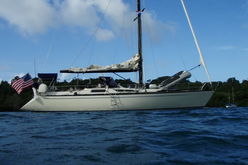 Slide: The Image of 1986 Baltic 48 DP sailboat anchored on calm water with American flag. - 2