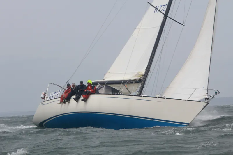 Slide: The Image of Sailing yacht Baltic 48 DP from 1986 navigating choppy waters with crew on deck. - 29