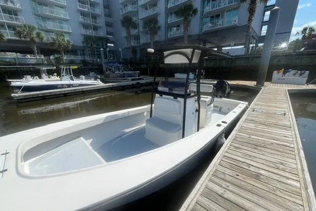 Slide: The Image of 2022 May-Craft 2300CC boat docked near waterfront buildings. - 2