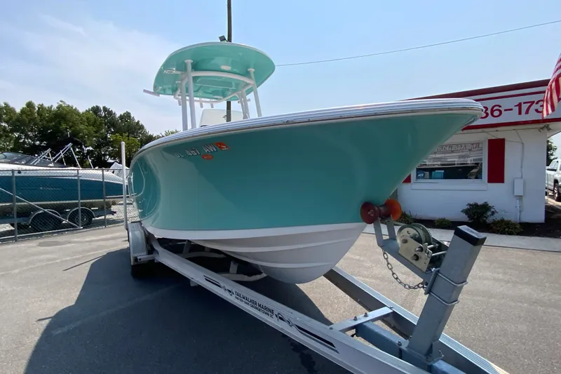 Slide: The Image of 2023 Sportsman Open 232 Center Console boat on trailer, teal hull, outdoor dealership. - 3