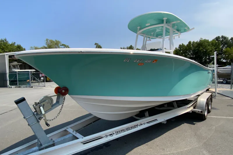 Slide: The Image of 2023 Sportsman Open 232 Center Console boat on trailer, teal hull, parked outdoors. - 5