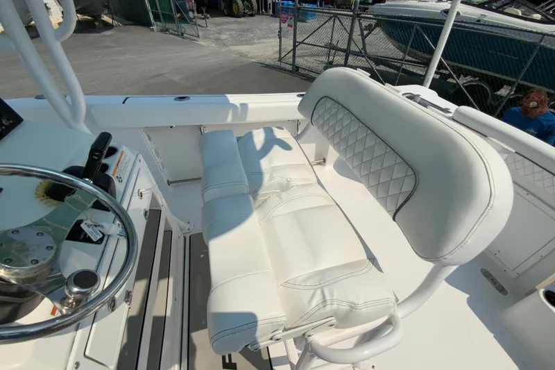 Slide: The Image of 2023 Sportsman Open 232 Center Console boat interior with white cushioned seating. - 16