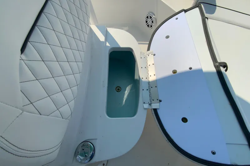 Slide: The Image of 2023 Sportsman Open 232 Center Console boat interior with storage compartment and cushioned seating. - 23