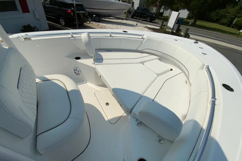 Slide: The Image of 2023 Sportsman Open 232 Center Console boat interior with white cushioned seating. - 22