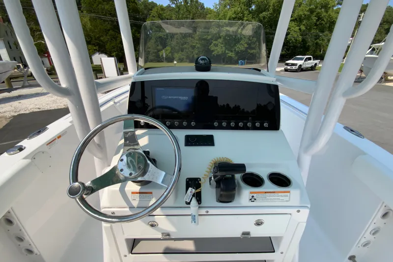 Slide: The Image of 2023 Sportsman Open 232 Center Console boat dashboard with steering wheel and controls. - 12