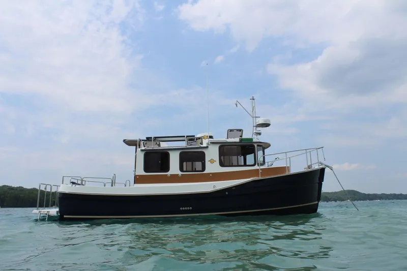 Slide: The Image of A 2015 Ranger Tugs R-27 on calm water under a cloudy sky. - 44