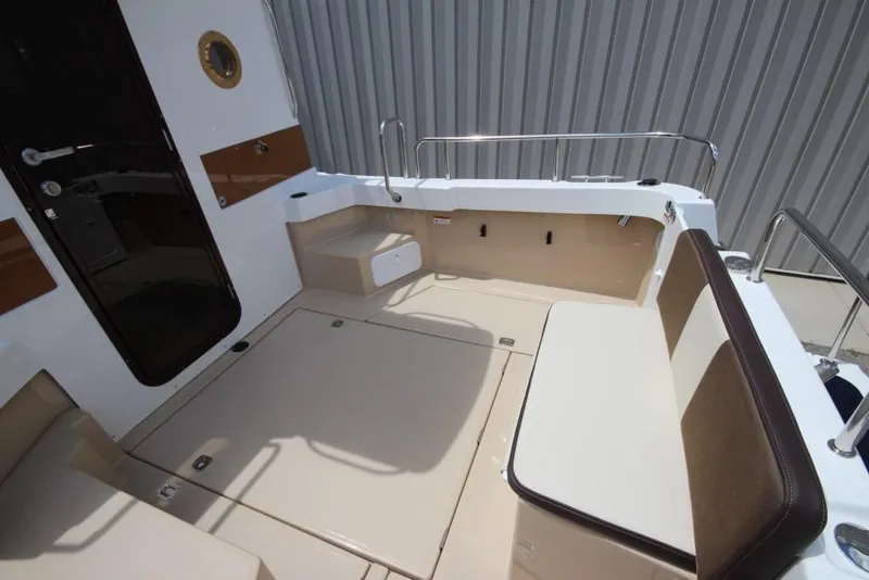 Slide: The Image of The image shows the cockpit of a 2015 Ranger Tugs R-27 with seating and storage. - 16