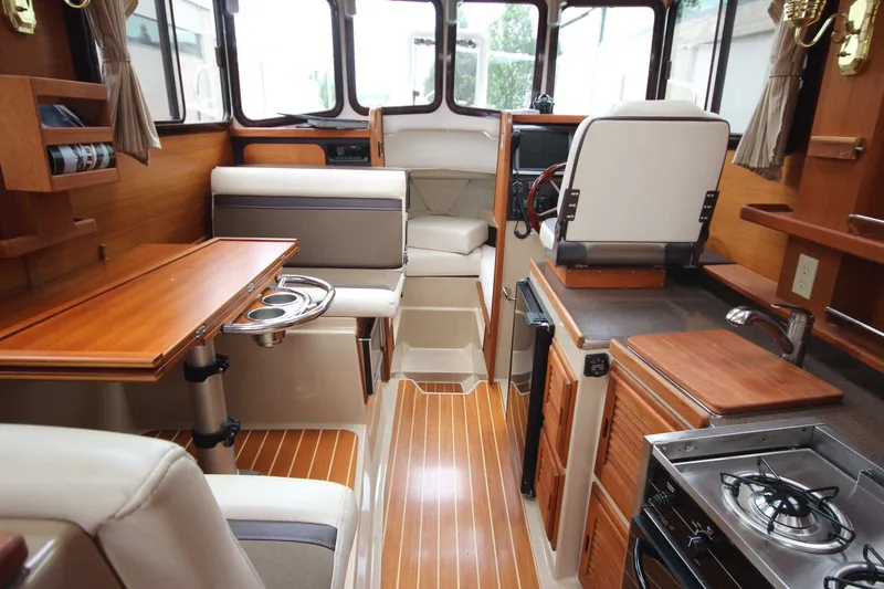 Slide: The Image of Interior of 2015 Ranger Tugs R-27 boat with wood accents and compact kitchen area. - 47