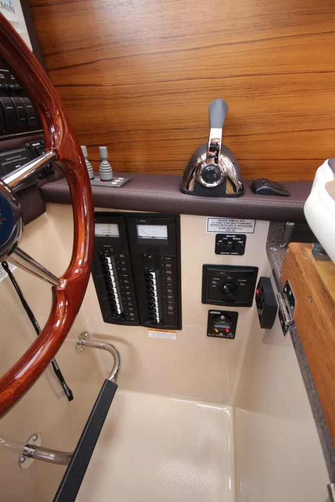Slide: The Image of The image shows the cockpit of a 2015 Ranger Tugs R-27 with steering wheel and throttle. - 29