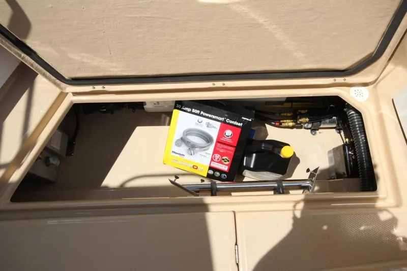 Slide: The Image of An open storage compartment on a Ranger Tugs R-27 boat with a cable and accessories. - 19