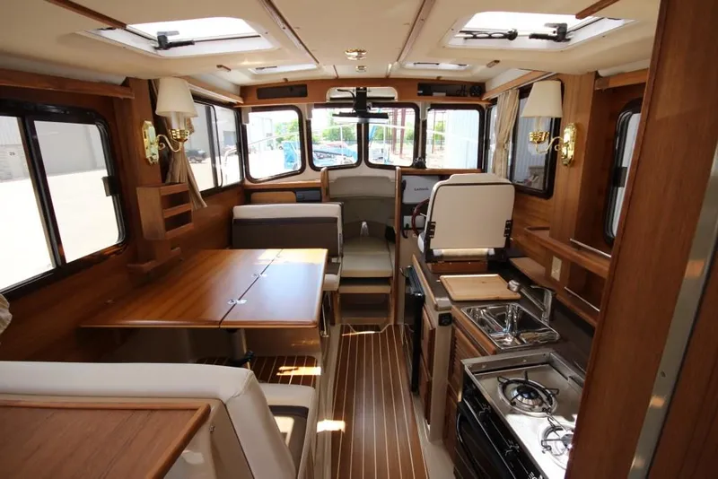 Slide: The Image of Interior of a 2015 Ranger Tugs R-27 with wood furnishings and a kitchenette. - 25