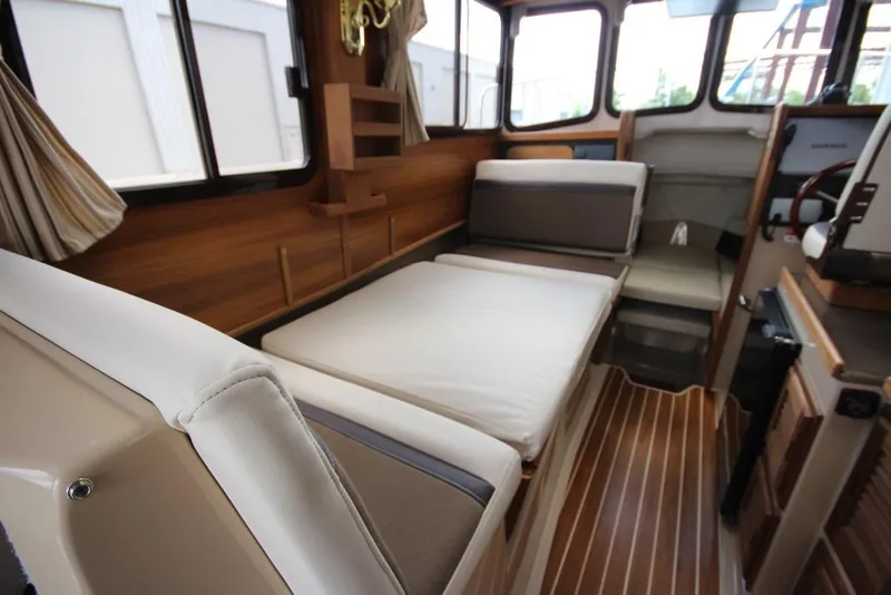 Slide: The Image of Interior of a 2015 Ranger Tugs R-27 with wood flooring and cushioned seating. - 33