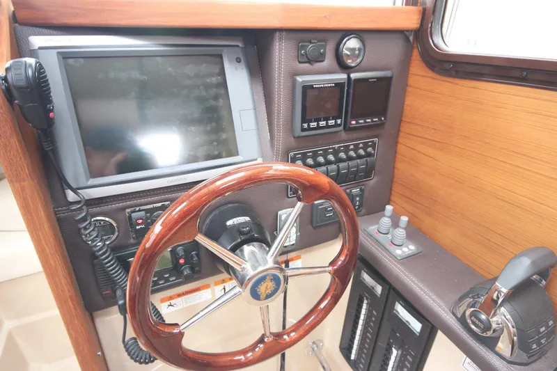 Slide: The Image of 2015 Ranger Tugs R-27 helm with Garmin navigation and wood steering wheel. - 49