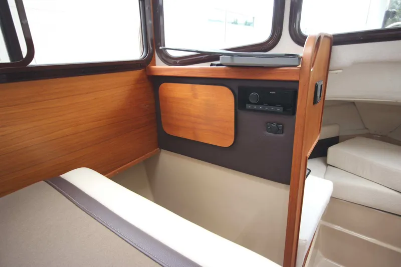 Slide: The Image of Interior of 2015 Ranger Tugs R-27 boat with wood paneling and seating area. - 50