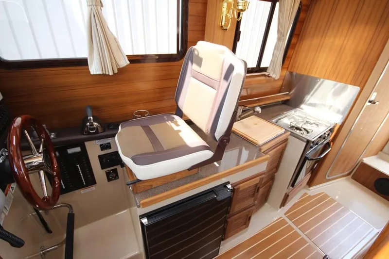 Slide: The Image of Interior of the 2015 Ranger Tugs R-27 with wood finish and modern kitchen. - 31
