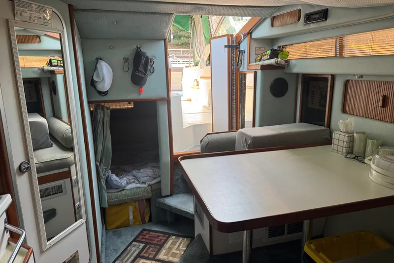 Slide: The Image of Interior of a 1989 Sea Ray 300 Sundancer boat, featuring a cozy cabin and dining area. - 16