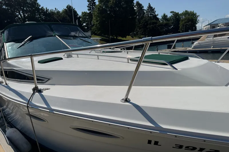 Slide: The Image of 1989 Sea Ray 300 Sundancer docked, featuring sleek white design and stainless steel railings. - 4