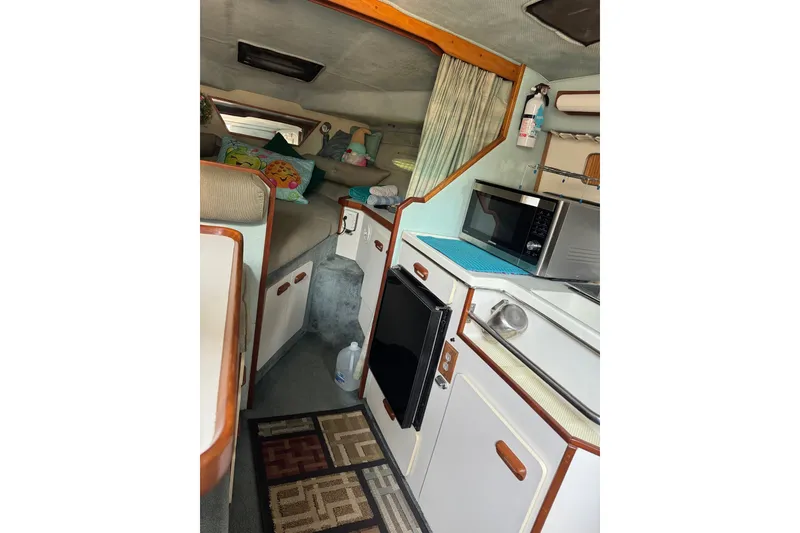 Slide: The Image of Interior of a 1989 Sea Ray 300 Sundancer boat with kitchenette and seating area. - 13