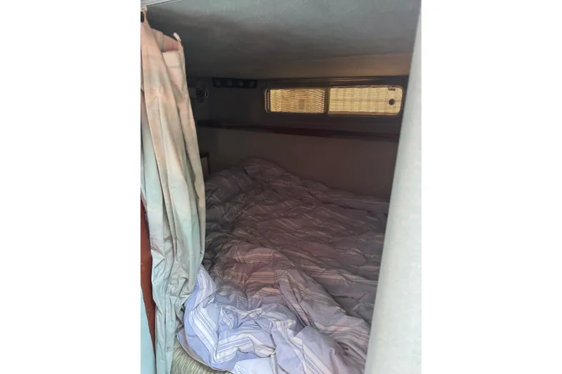 Slide: The Image of Cozy cabin interior of 1989 Sea Ray 300 Sundancer with bed and window. - 12