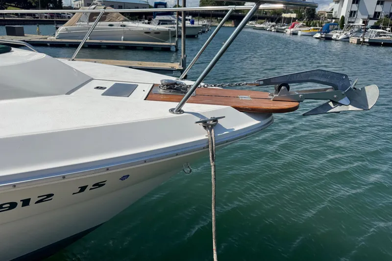 Slide: The Image of 1989 Sea Ray 300 Sundancer anchored at marina, showcasing bow and anchor details. - 3