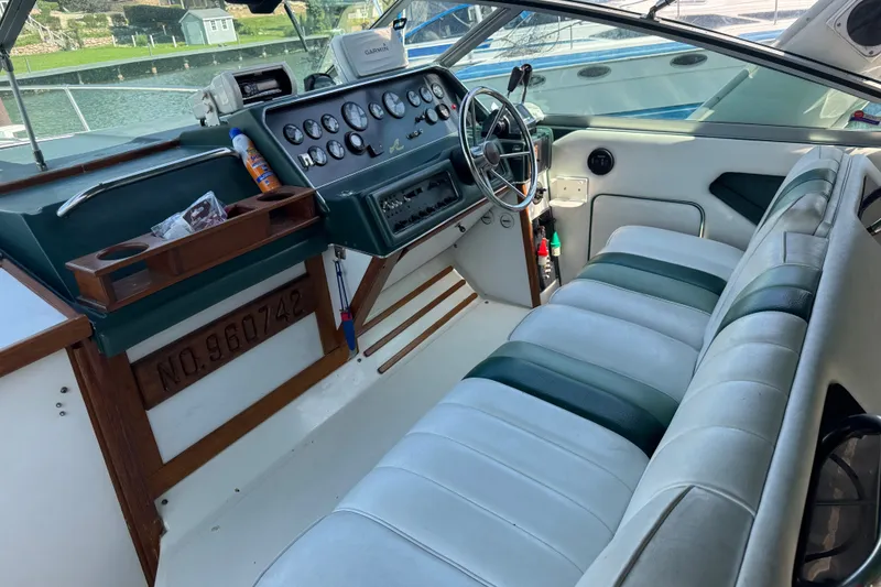 Slide: The Image of 1989 Sea Ray 300 Sundancer cockpit with vintage dashboard and white seating. - 22